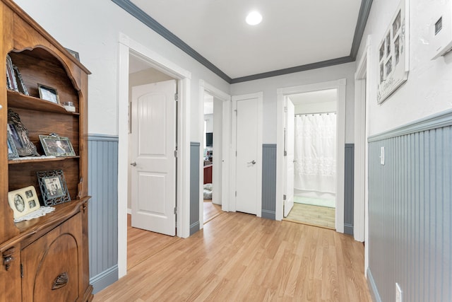 hallway featuring crown molding and light wood-type flooring