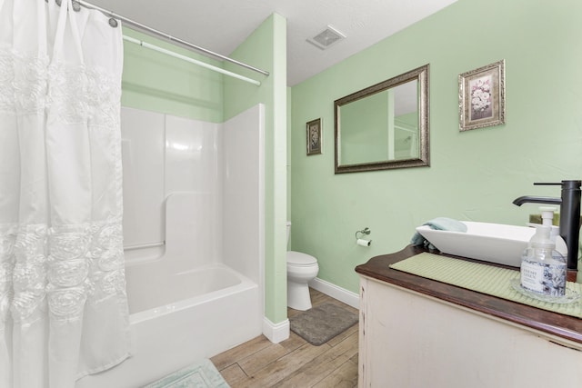 full bathroom featuring shower / bath combo, hardwood / wood-style flooring, toilet, and sink