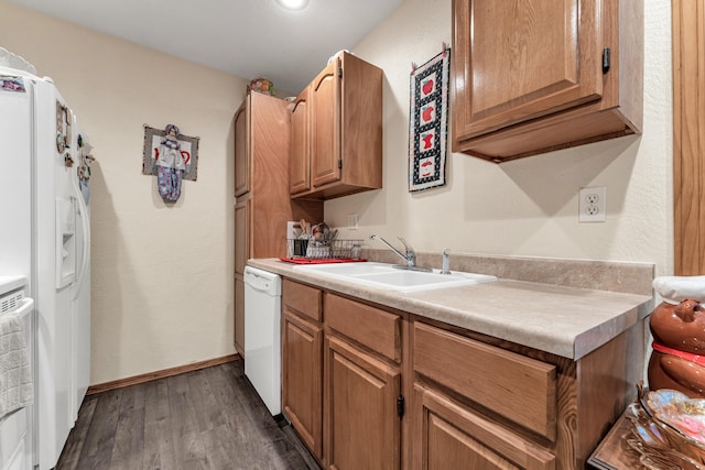 kitchen featuring white appliances, dark wood-type flooring, and sink