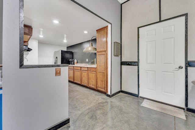 kitchen with hanging light fixtures and stainless steel refrigerator