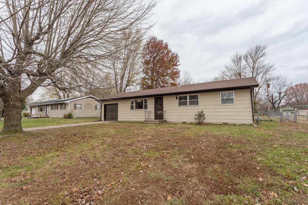 single story home with a garage and a front yard