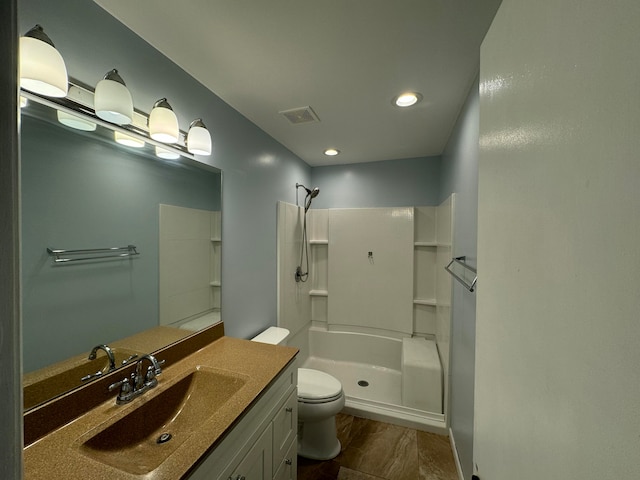 bathroom with a shower, vanity, and toilet