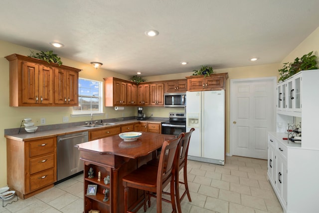 kitchen featuring a breakfast bar area, sink, a kitchen island, and appliances with stainless steel finishes