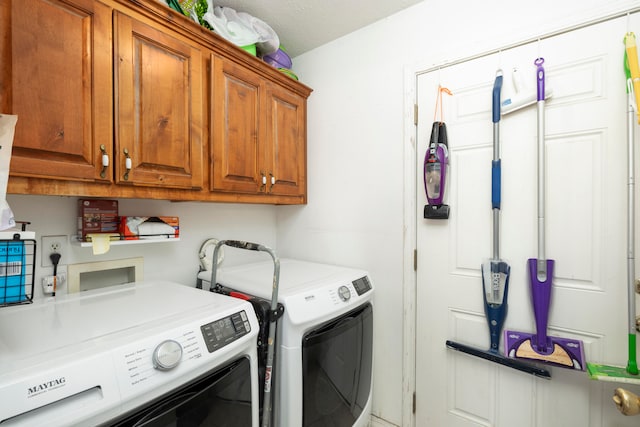 washroom featuring cabinets, washing machine and dryer, and a textured ceiling