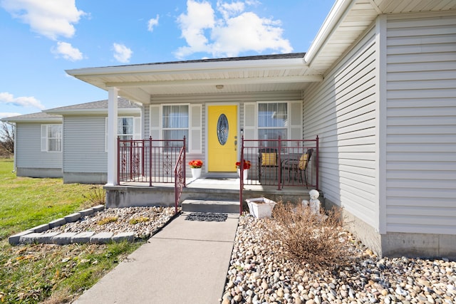 view of exterior entry featuring covered porch