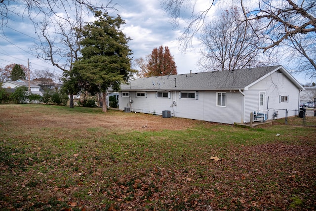 back of property with a yard and central AC unit