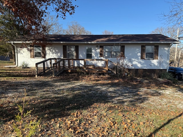 ranch-style house with a wooden deck and a front lawn