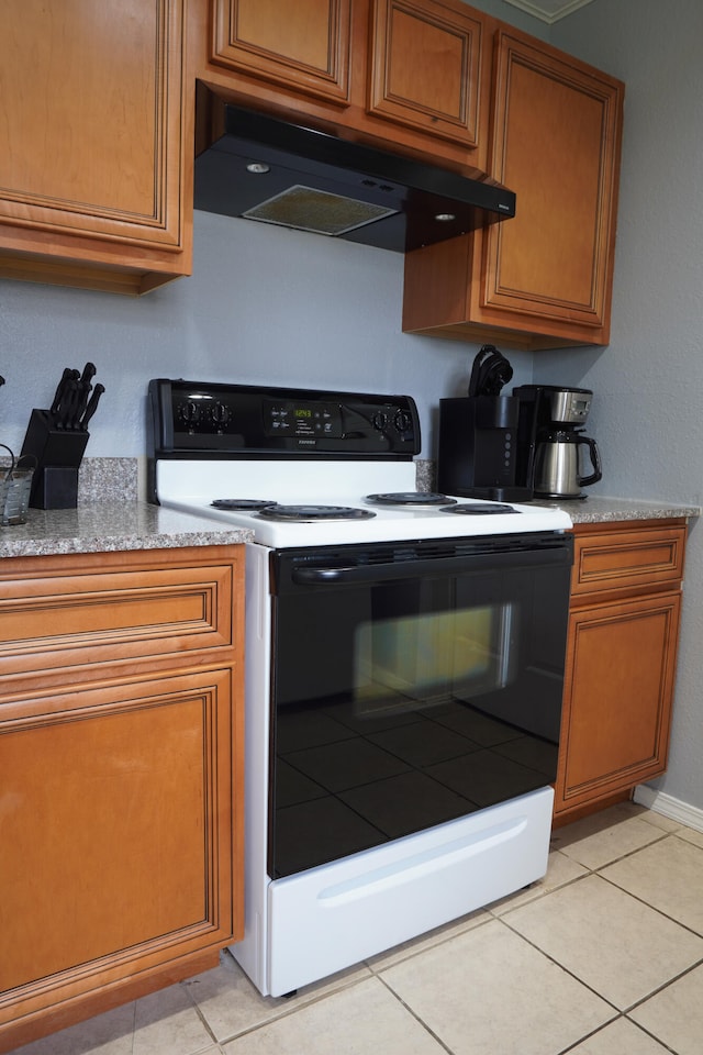 kitchen with light stone countertops, electric stove, and light tile patterned floors