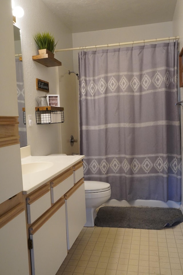 full bathroom featuring tile patterned floors, shower / tub combo with curtain, vanity, and toilet