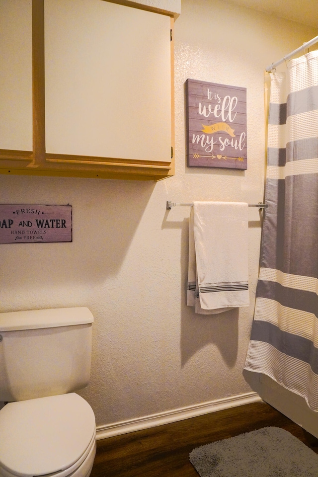 bathroom featuring wood-type flooring and toilet