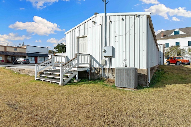 view of outbuilding with central AC and a lawn