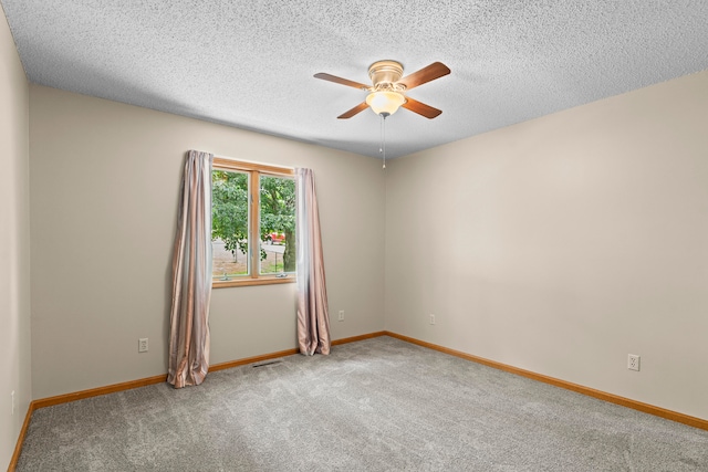 unfurnished room with carpet, ceiling fan, and a textured ceiling