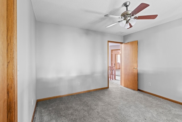 spare room with ceiling fan, carpet floors, and a textured ceiling