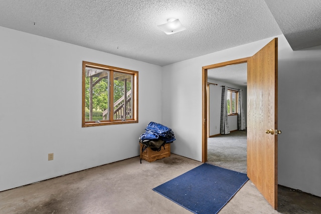 unfurnished room with a healthy amount of sunlight and a textured ceiling