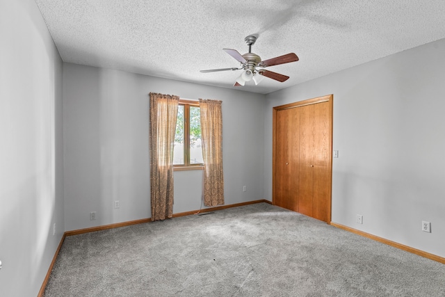 carpeted empty room with ceiling fan and a textured ceiling