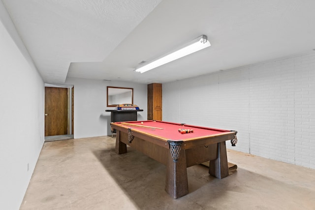 recreation room with brick wall and billiards