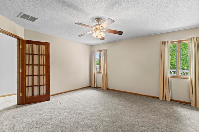 carpeted spare room with ceiling fan and a textured ceiling