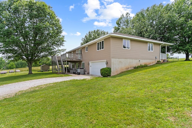 view of side of property with a yard, a garage, and a wooden deck