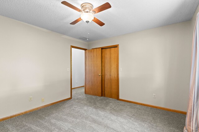 unfurnished bedroom featuring a textured ceiling, ceiling fan, light carpet, and a closet