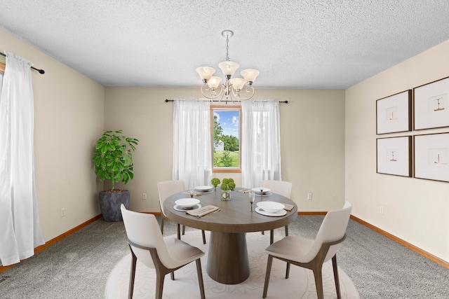 carpeted dining room with a chandelier and a textured ceiling