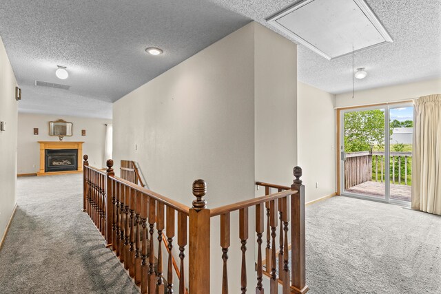 hallway featuring carpet floors and a textured ceiling