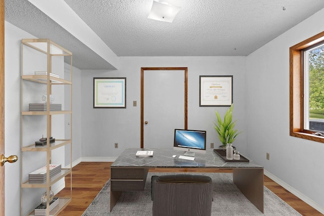 office with wood-type flooring and a textured ceiling