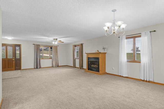 unfurnished living room with carpet, ceiling fan with notable chandelier, and a textured ceiling