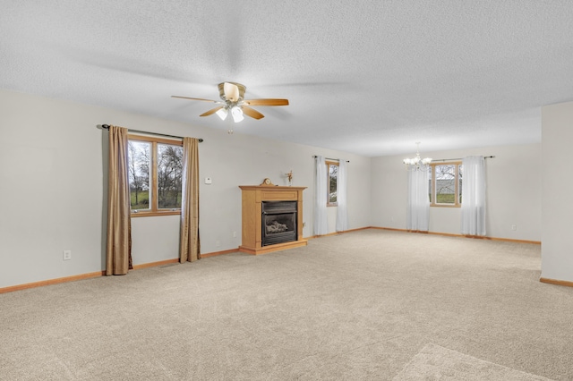 unfurnished living room with carpet flooring, a textured ceiling, and ceiling fan with notable chandelier