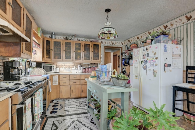 kitchen featuring a textured ceiling, hanging light fixtures, and appliances with stainless steel finishes