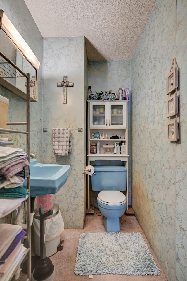 bathroom with toilet and a textured ceiling