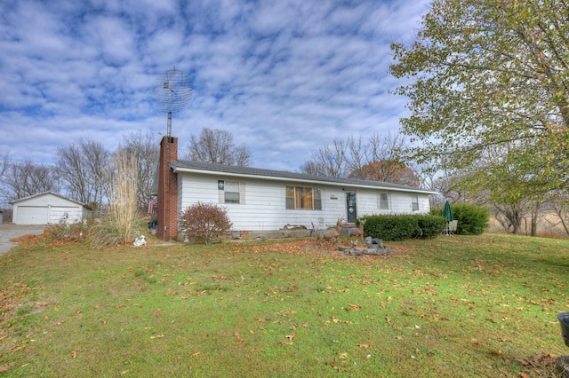 ranch-style home with a garage, an outbuilding, and a front yard