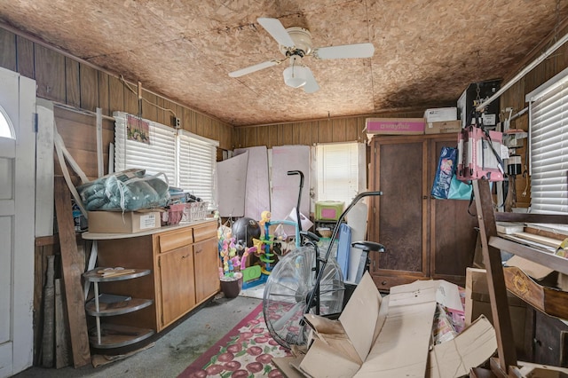 misc room with ceiling fan and wood walls