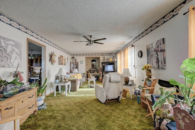 living room featuring carpet flooring, ceiling fan, and a textured ceiling