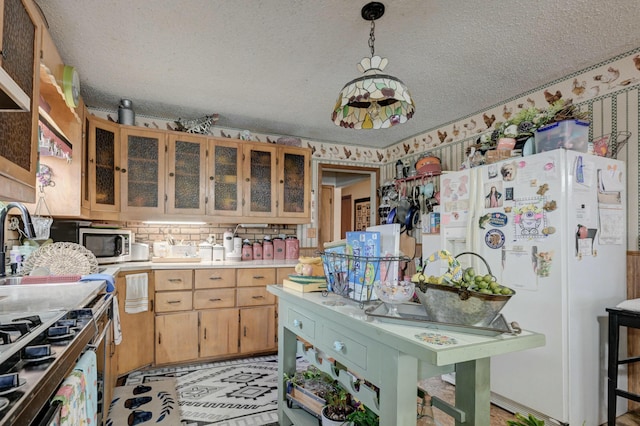 kitchen featuring decorative light fixtures, a textured ceiling, white fridge, and backsplash