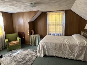 bedroom featuring carpet, lofted ceiling, and wood walls