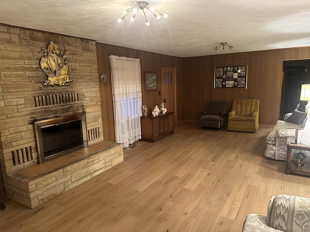 312 E Maple St, West Plains, MO 65775 - living room featuring a large fireplace, wood finished floors, wood walls, and a chandelier