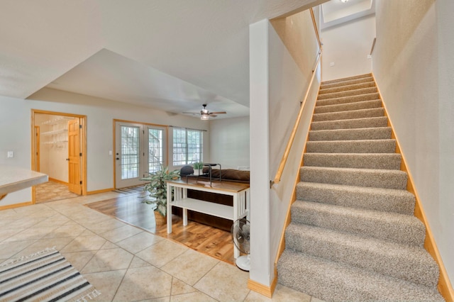 staircase featuring ceiling fan, hardwood / wood-style floors, and french doors