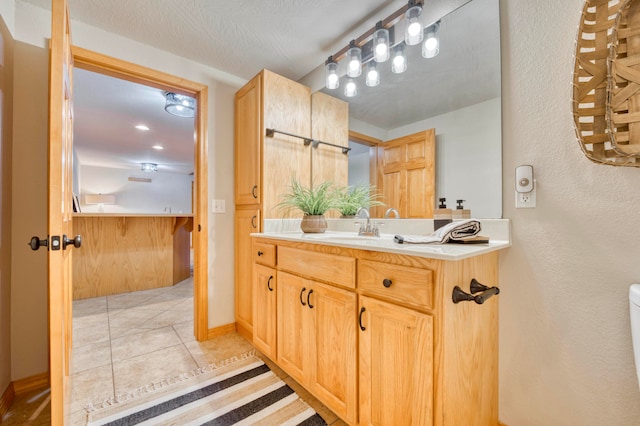 bathroom with tile patterned flooring, vanity, and toilet