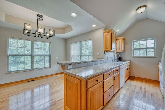 kitchen featuring pendant lighting, dishwasher, kitchen peninsula, and a wealth of natural light