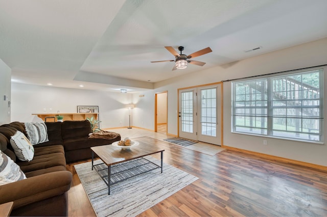 living room featuring ceiling fan, light hardwood / wood-style floors, and a wealth of natural light