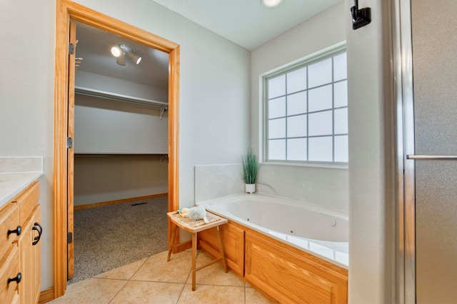 bathroom with a tub to relax in, tile patterned flooring, and vanity