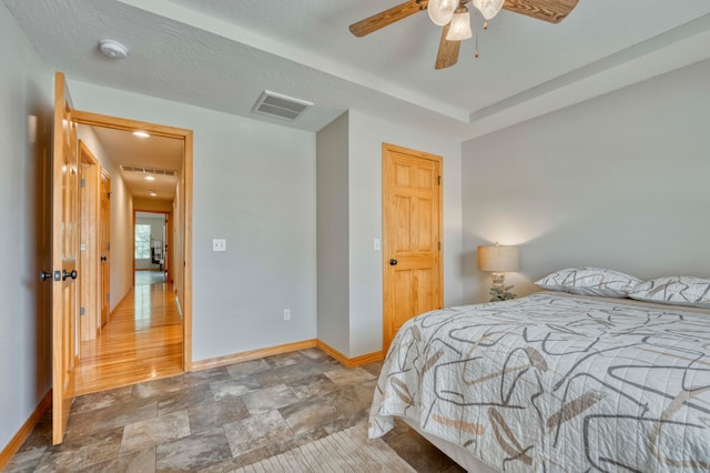 bedroom featuring ceiling fan, wood-type flooring, and a textured ceiling