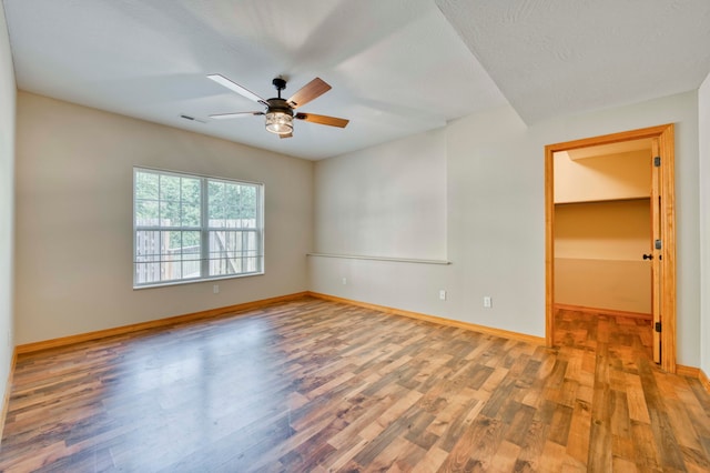 spare room featuring ceiling fan, wood-type flooring, and a textured ceiling