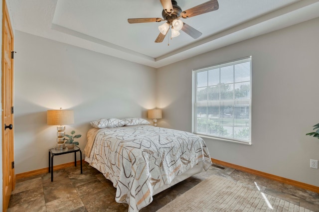 bedroom with a tray ceiling and ceiling fan