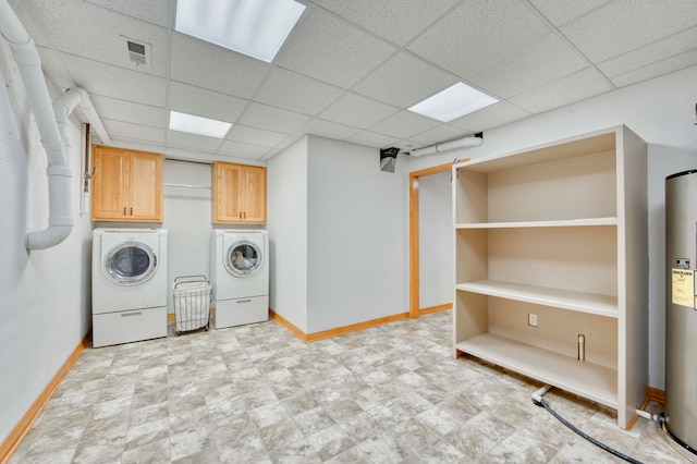 washroom with washing machine and dryer, water heater, and cabinets