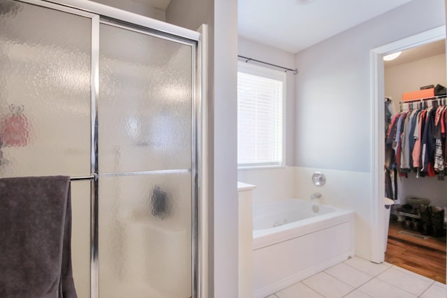 bathroom featuring shower with separate bathtub and tile patterned flooring