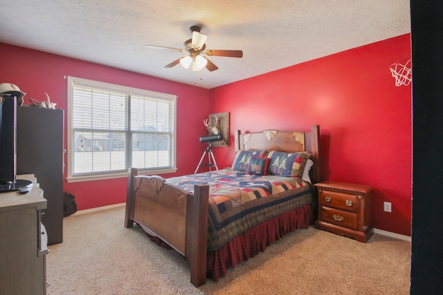 bedroom featuring a textured ceiling, light colored carpet, and ceiling fan