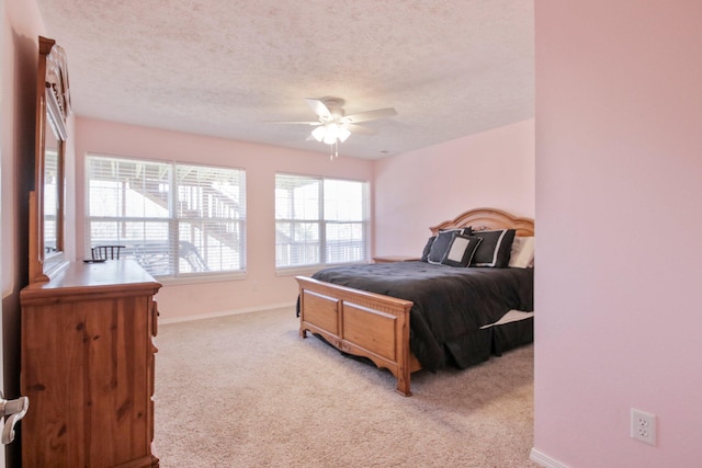 carpeted bedroom featuring ceiling fan and a textured ceiling