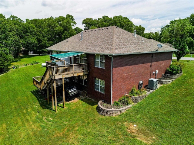 rear view of property with a wooden deck, central AC, and a lawn