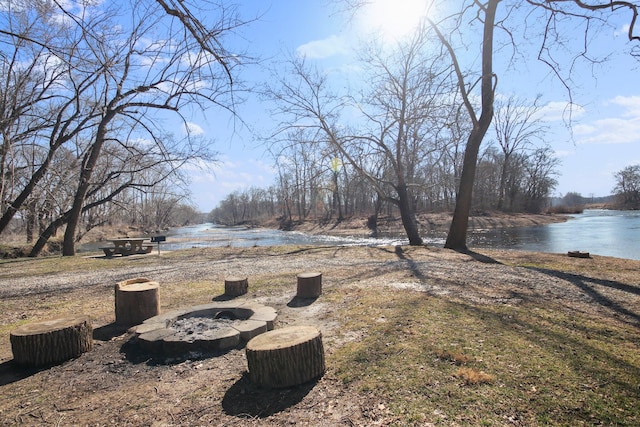 view of yard with a water view and a fire pit